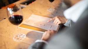 restaurant menu next to glass of wine