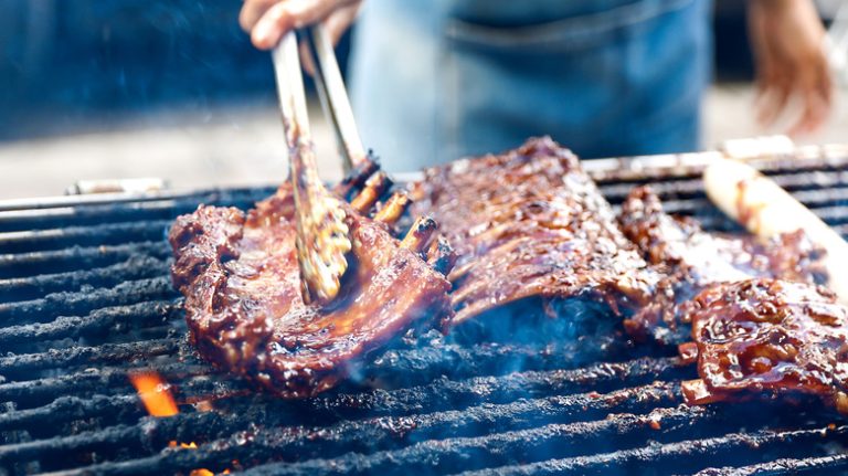 turning smoked ribs on the grill